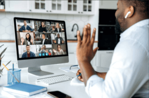 Man sitting at a desk in a video call participating in a scholarship coaching program